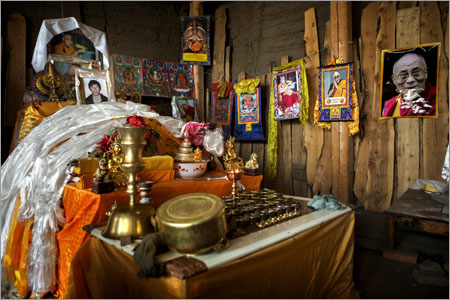 A shrine for Gongbu Tserang, 23, who self-immolated himself on 13th November 2012, is seen alongside a photo of the Dalai Lama in his family home in Ahlaxiang Village, in the Tibetan area of Gansu Province, China on Dec. 16, 2012.
