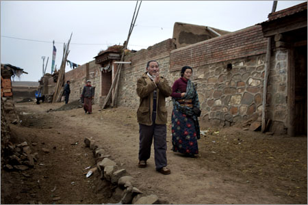 The father (left) of Tsering Dondhup, 35, who self-immolated on 26th November 2012 in protest at a nearby Han Chinese mine, prays as he walks near his family home with other family members in Amchok Village in the Tibetan area of Gansu Province, China on