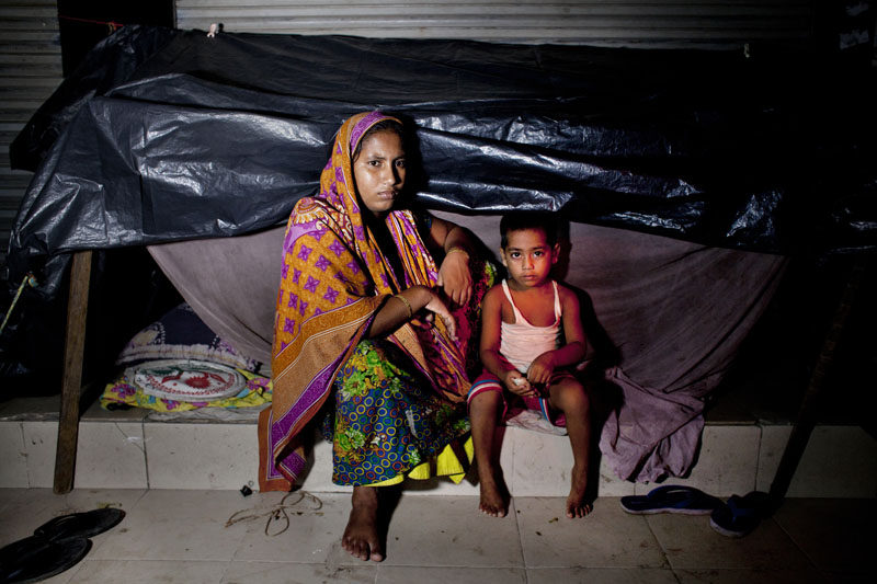 Amena and her daughter, Ishma, and her mother, Sobira  who all live on the streets get ready to go to slep on the pavements of Panthakunja, Dhaka.