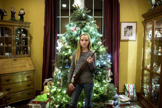Ralea (12) stands in the living room of her family home with a rifle. She has been shooting guns for a few years and currently competes in skeet shooting competitions as a member of the Oklahoma Junior High School Rodeo Association skeet shooting team. Ralea is scheduled to compete at the national competition in the summer of 2015.